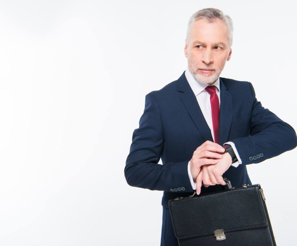 A man wearing a business suit looking at his watch